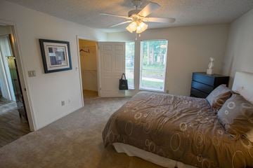 Indianapolis apartment for rent - a bedroom with a large bed and a ceiling fan