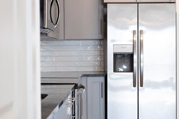 A kitchen with white cabinets and stainless steel appliances