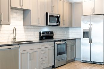 A kitchen with white cabinets and stainless steel appliances