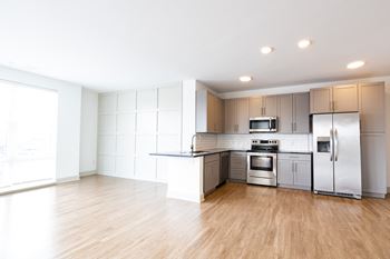 A kitchen with white cabinets and a wooden floor