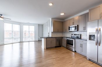 A kitchen with gray cabinets and a wooden floor