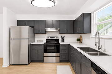 Nashville apartment for rent - A modern kitchen with black cabinets and stainless steel appliances.