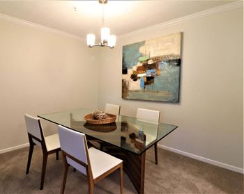 A dining room with a glass table and chairs
