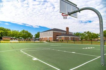 A basketball court with a basketball hoop and a building in the background.