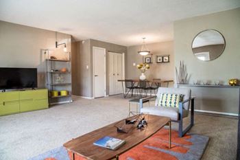 A living room with a grey couch and a wooden coffee table.