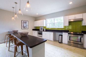A kitchen with a black countertop and white cabinets.