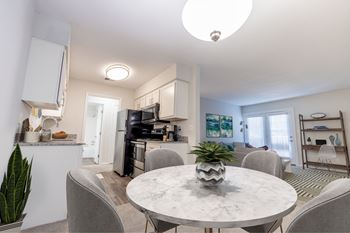 A kitchen with a table and chairs in the foreground.