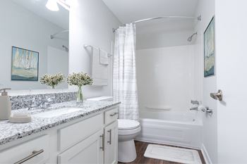 A white bathroom with a toilet, sink, and bathtub.