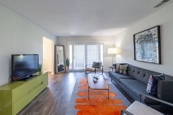 A living room with a grey couch and a yellow cabinet.