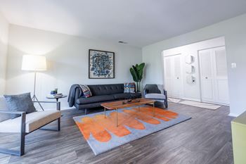 A living room with a black couch and a grey sofa.