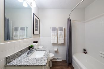 A bathroom with a sink, toilet, and bathtub.