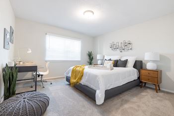 A bedroom with a bed, desk, and chair.