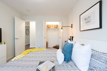 A bedroom with a bed, a dresser, and a painting on the wall.