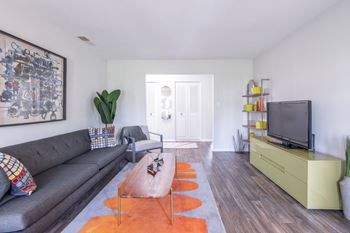 A living room with a grey couch, a brown rug, and a yellow cabinet.