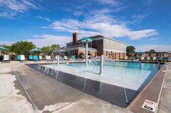 A large outdoor swimming pool with a building in the background.