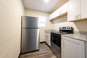 A kitchen with stainless steel appliances and white cabinets