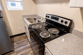 An empty kitchen with a stove and a sink