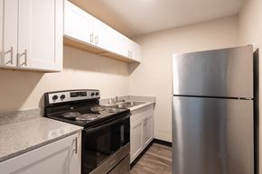 Indianapolis apartment for rent - a kitchen with white cabinets and stainless steel appliances and a refrigerator