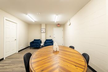 A conference room with a large wooden table and chairs