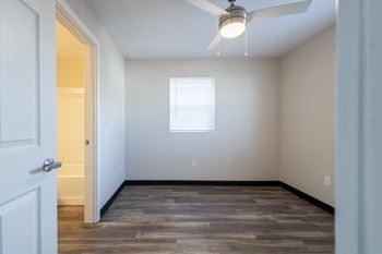 An empty room with wood floors and a window
