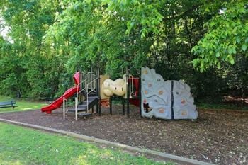 A playground with a slide and other toys in a park