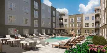 A pool area with lounge chairs and a person standing in the pool.
