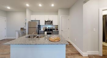 A kitchen with a granite countertop and a blue island.
