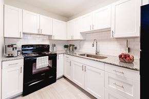 Indianapolis apartment for rent - a kitchen with white cabinets and black appliances