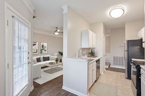 Conyers apartment for rent - A kitchen with white cabinets and a black refrigerator.