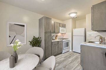 Doylestown apartment for rent - A kitchen with a white table and a vase with flowers on it.