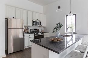 Philadelphia apartment for rent - a kitchen with white cabinets and stainless steel appliances and a marble counter top