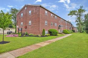 Feasterville apartment for rent - A red brick building with a green lawn in front.