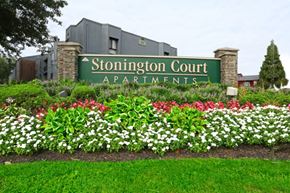 Lindenwold apartment for rent - A sign for Stonington Court Apartments is surrounded by flowers.