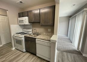 Blackwood apartment for rent - A kitchen with a white stove top oven and a white microwave above it.