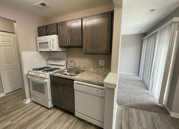 Blackwood apartment for rent - A kitchen with a white stove top oven and a white microwave above it.