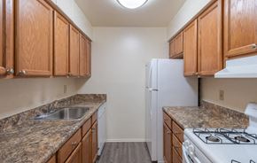 Lebanon apartment for rent - A kitchen with brown cabinets and a white refrigerator.