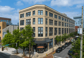 Wilmington apartment for rent - A street view of a large building with a parking lot in front.