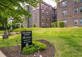 Bryn Mawr apartment for rent - A sign for Bryn Mawr Gables Apartments is in the foreground of a grassy area.