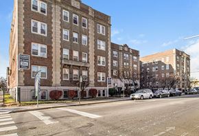 Philadelphia apartment for rent - A street view of a residential area with apartment buildings and parked cars.