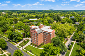 Bryn Mawr apartment for rent - A large red brick building sits in the middle of a green landscape.