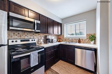 Camp Hill apartment for rent - A kitchen with dark wood cabinets and stainless steel appliances.