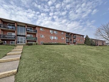 Camp Hill apartment for rent - A large grassy area in front of a brick apartment building.