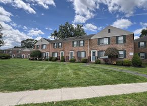 Horseheads apartment for rent - a large brick apartment building with a lawn and a sidewalk