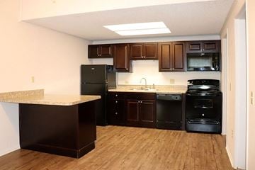 York apartment for rent - A kitchen with black appliances and wooden cabinets.