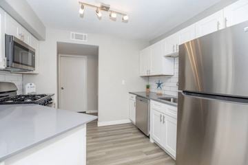Las Vegas apartment for rent - A modern kitchen with stainless steel appliances and white cabinetry.