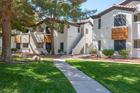 Las Vegas apartment for rent - A white building with a brown awning and a tree in front.
