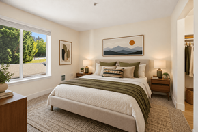 Troutdale apartment for rent - A bedroom with a large bed and a painting of a sunset on the wall.