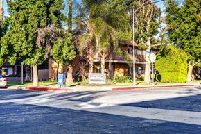 Reseda apartment for rent - an empty street in front of a building with palm trees