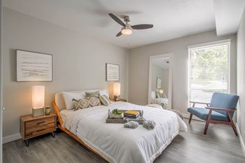 A bedroom with a bed and a ceiling fan