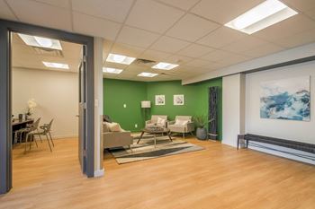 A living room with a wood floor and a green wall